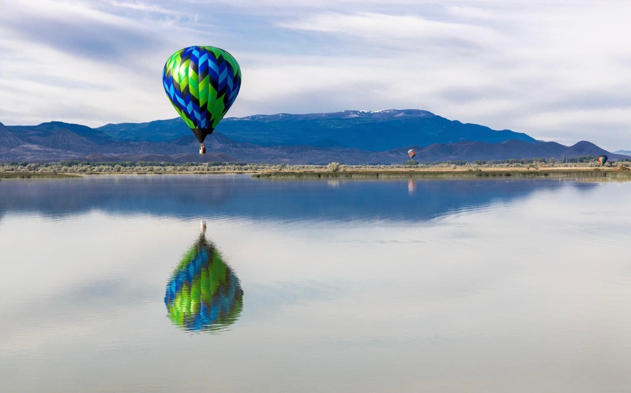 Hot air balloon floating over Utah mountains at sunrise
